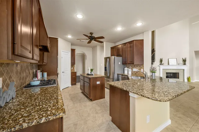 a kitchen with stainless steel appliances granite countertop a sink refrigerator and cabinets