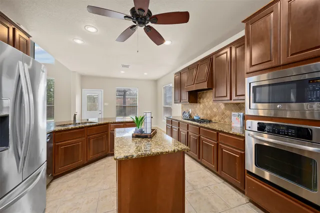 a kitchen with granite countertop stainless steel appliances and wooden cabinets
