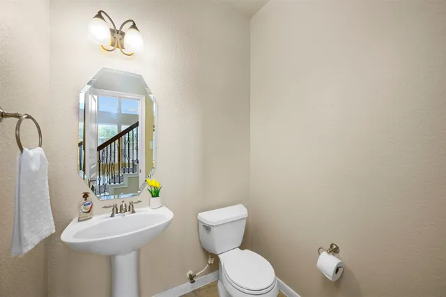 an empty room with a chandelier fan and windows