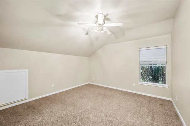 an empty room with a window and a fan