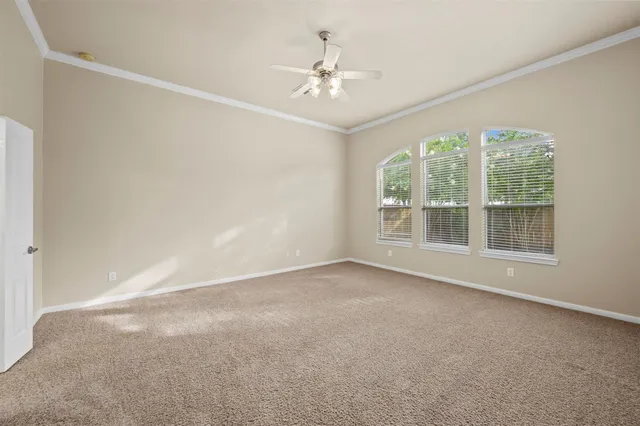 an empty room with a window and a ceiling fan