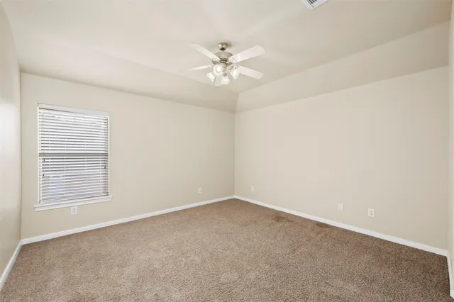 a view of an empty room with a ceiling fan