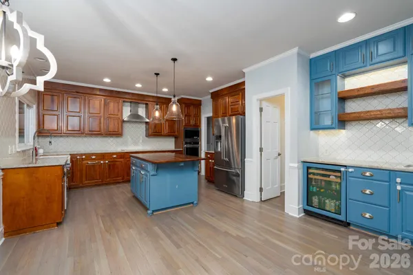 a kitchen with stainless steel appliances kitchen island granite countertop a refrigerator and a stove top oven