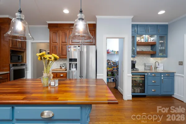a kitchen with stainless steel appliances kitchen island granite countertop a refrigerator stove and sink