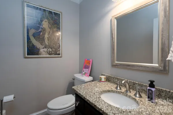 a bathroom with a toilet a sink and mirror