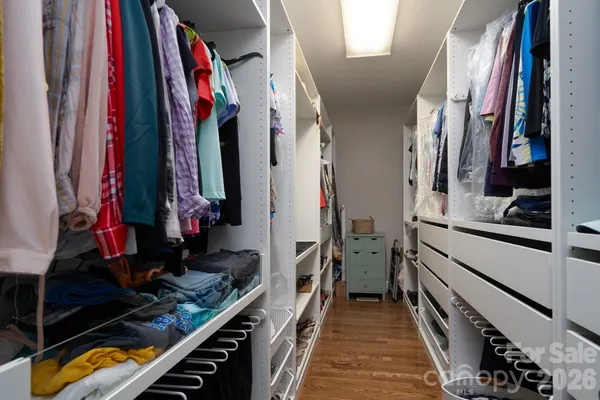 a view of walk in closet with clothes and shoes