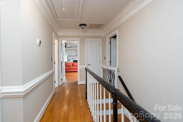 a view of a hallway with wooden floor and staircase