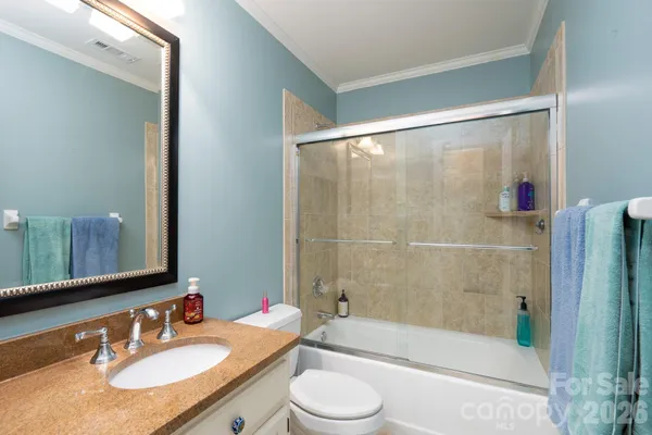 a bathroom with a granite countertop tub sink toilet a mirror a bathtub and shower