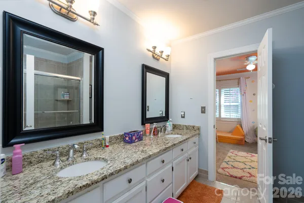 a bathroom with a granite countertop double vanity sink and a mirror