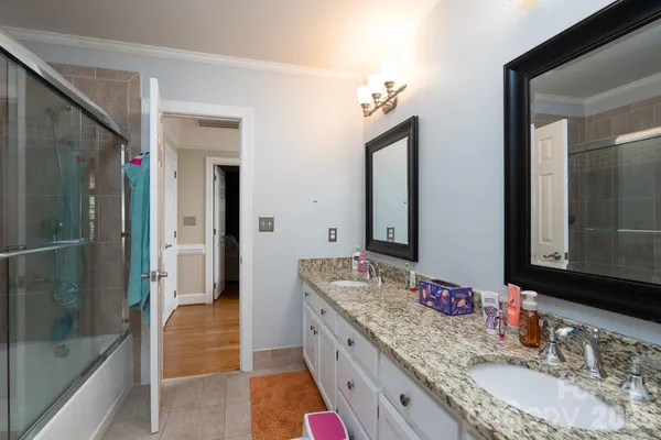 a bathroom with a granite countertop double vanity sink and a mirror