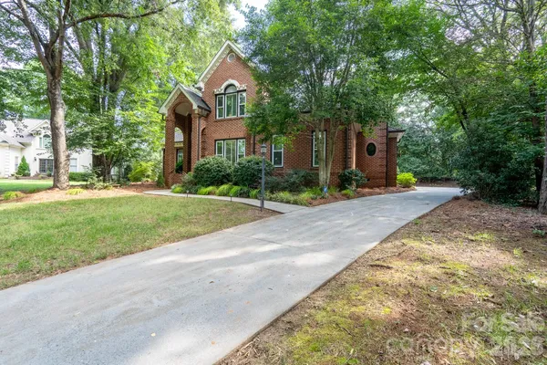 a front view of a house with a yard and trees