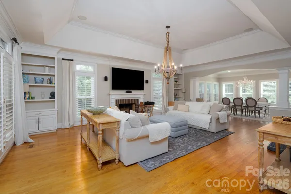 a living room with furniture a chandelier and a flat screen tv