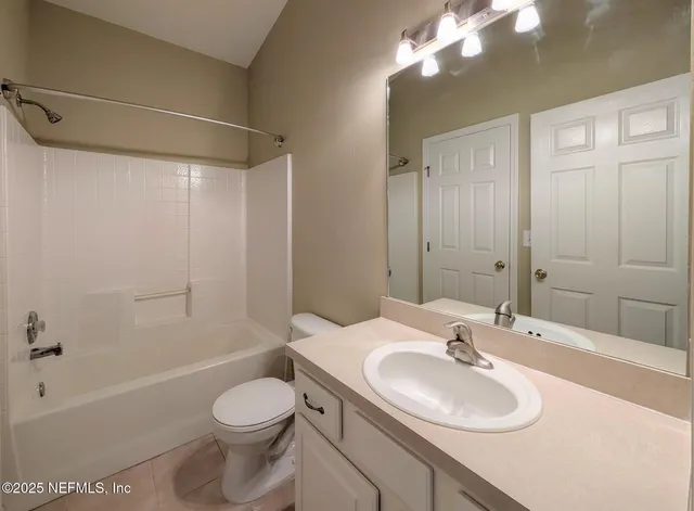 an empty room with windows and chandelier fan