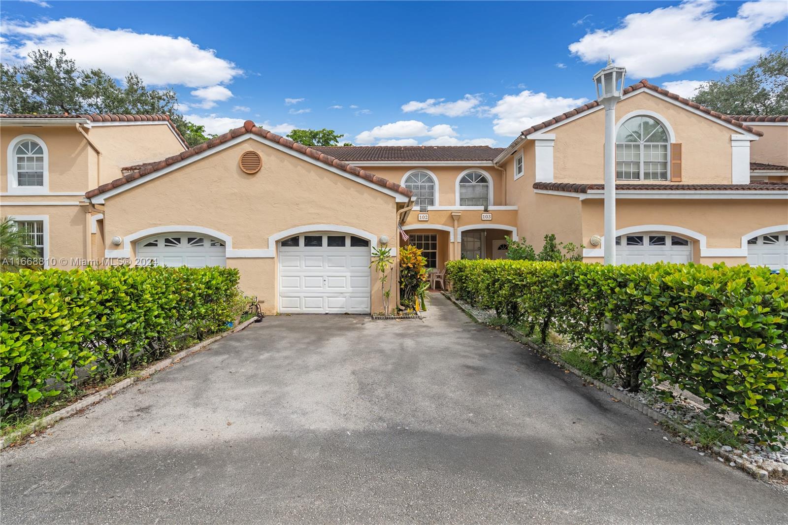 14807 Balgowan Road, Unit 10212 Miami Lakes, FL 33016 - Photo 19 of 32 a view of a white house with large windows and plants