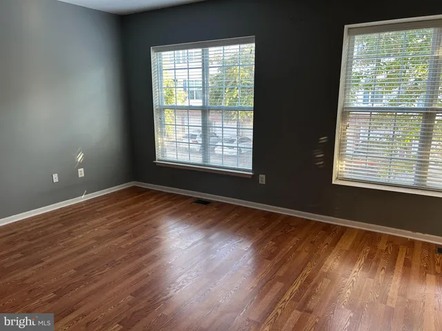 a view of empty room with wooden floor