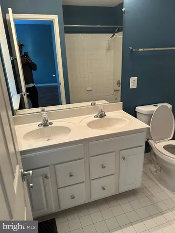 a bathroom with a sink and mirror with toilet
