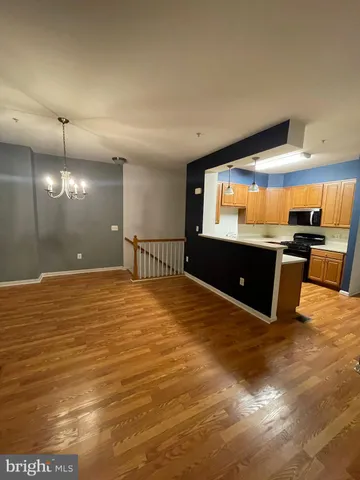a view of a livingroom with a fireplace a chandelier and wooden floor