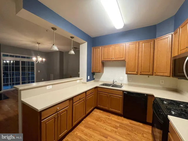 a kitchen with granite countertop a sink cabinets and stainless steel appliances