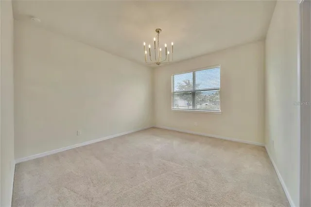 an empty room with windows and chandelier