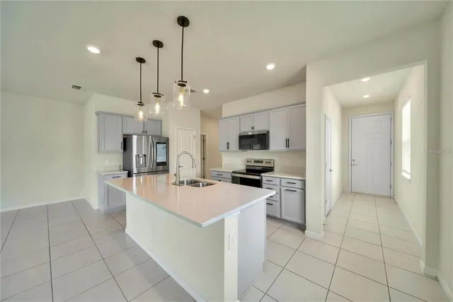 a kitchen with a sink a counter top space and stainless steel appliances