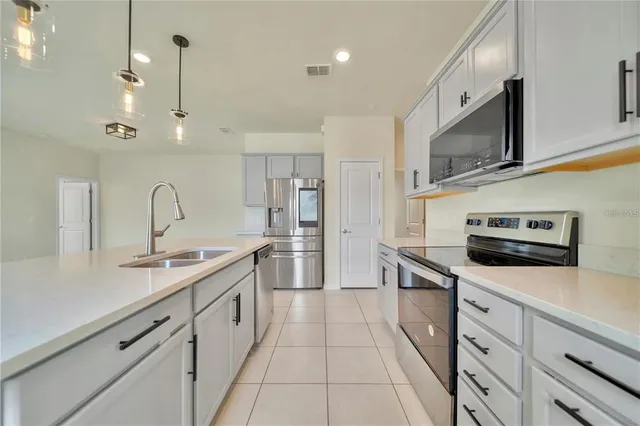 a kitchen with stainless steel appliances granite countertop a sink a stove and a refrigerator