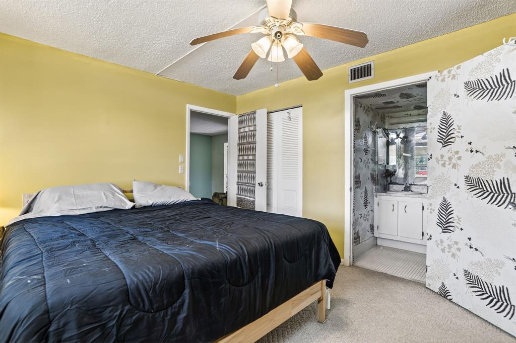 7360 Northwest 18th Street, Unit 103 Margate, FL 33063 - Photo 17 of 24 a bedroom with a bed and a chandelier