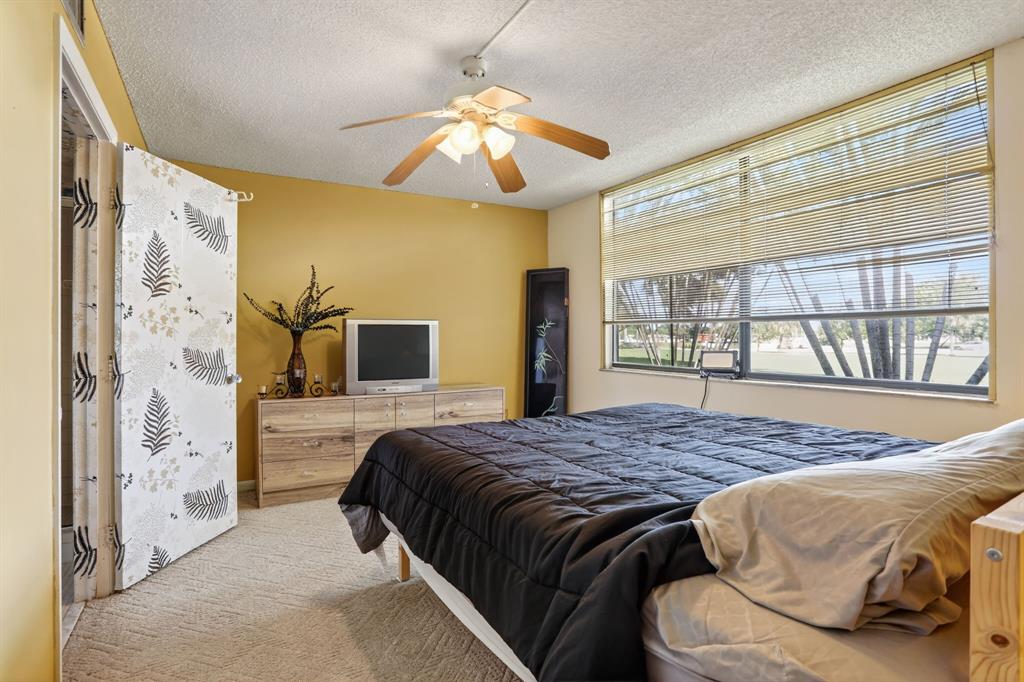 7360 Northwest 18th Street, Unit 103 Margate, FL 33063 - Photo 18 of 24 a bedroom with a bed and a window