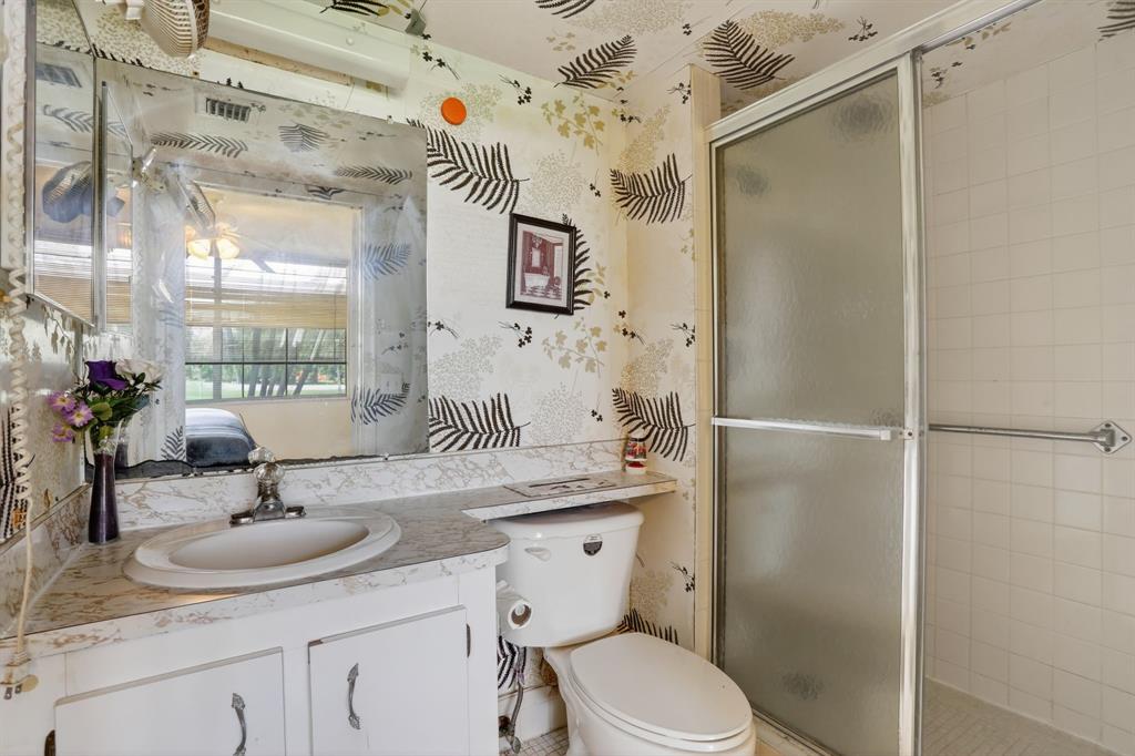 7360 Northwest 18th Street, Unit 103 Margate, FL 33063 - Photo 19 of 24 a bathroom with a sink toilet a mirror and shower