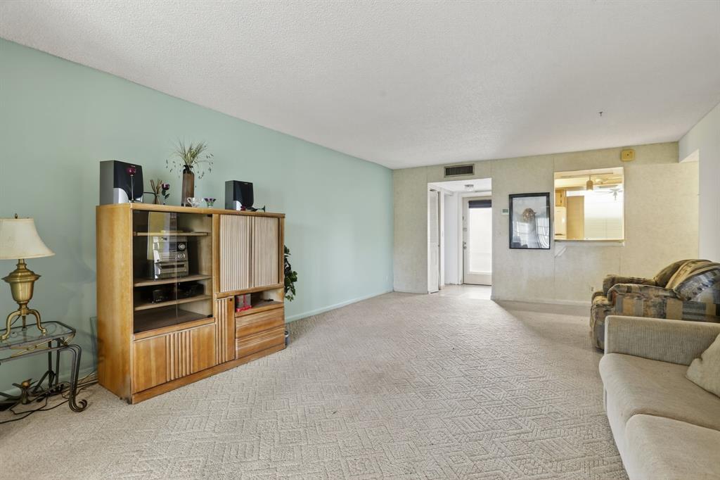 7360 Northwest 18th Street, Unit 103 Margate, FL 33063 - Photo 9 of 24 a living room with furniture and a flat screen tv