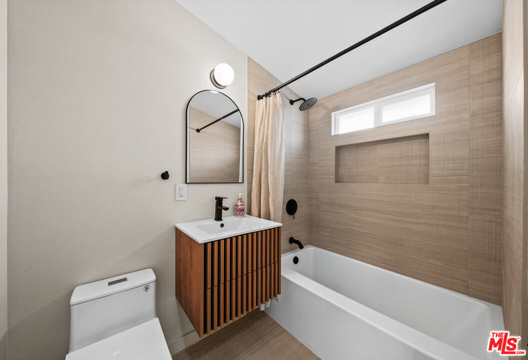 20308 Mobile Street Winnetka, CA 91306 - Photo 16 of 28 a bathroom with a sink a toilet and shower