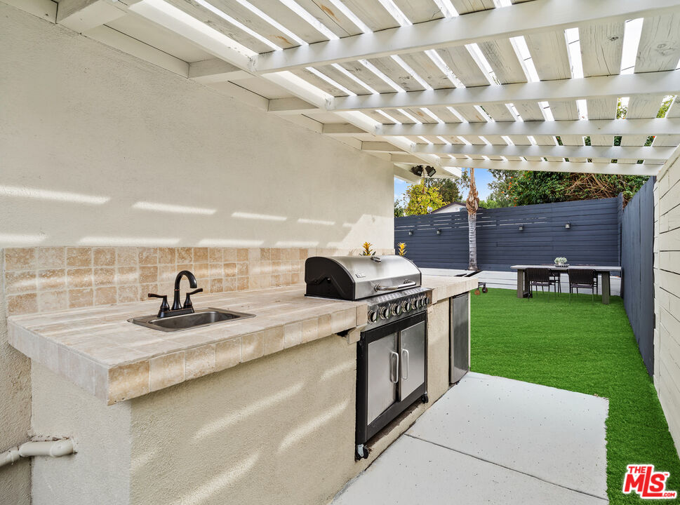20308 Mobile Street Winnetka, CA 91306 - Photo 21 of 28 a kitchen with a sink and a stove top oven