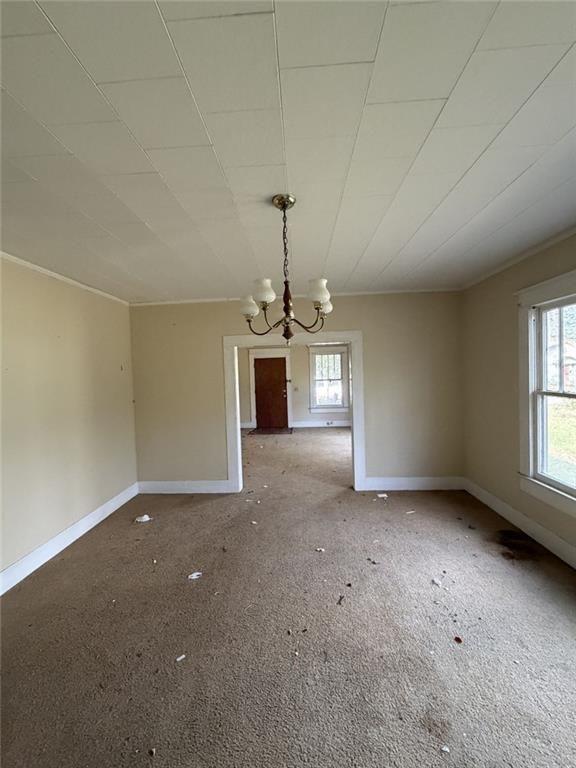 320 West Magnolia Street Fitzgerald, GA 31750 - Photo 2 of 16 en empty room with windows and chandelier fan