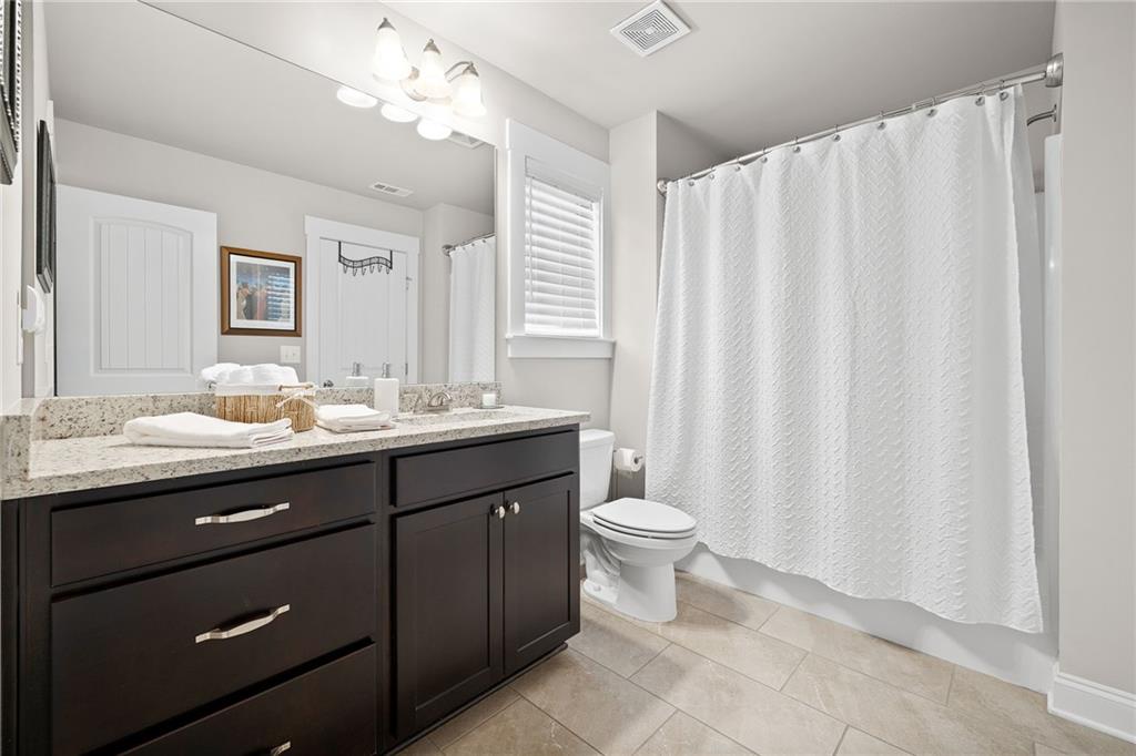 2440 Traditions Way Jefferson, GA 30549 - Photo 22 of 32 a bathroom with a double vanity sink a toilet and a mirror