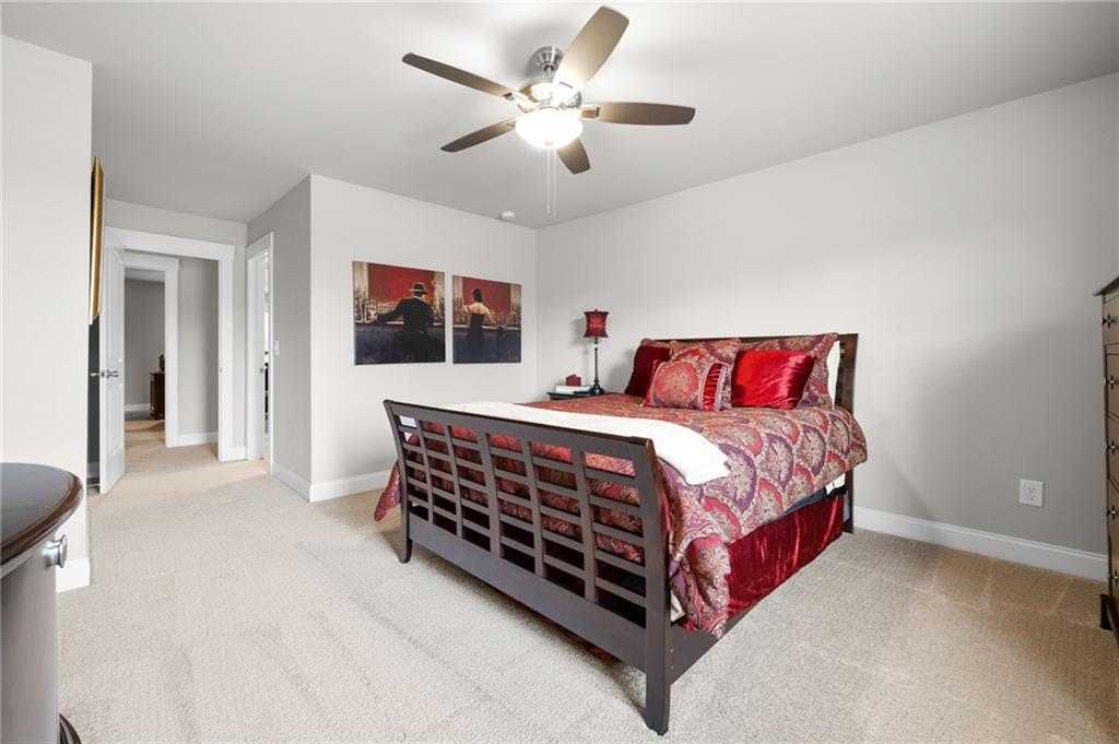 2440 Traditions Way Jefferson, GA 30549 - Photo 24 of 32 a bedroom with a bed and a chandelier