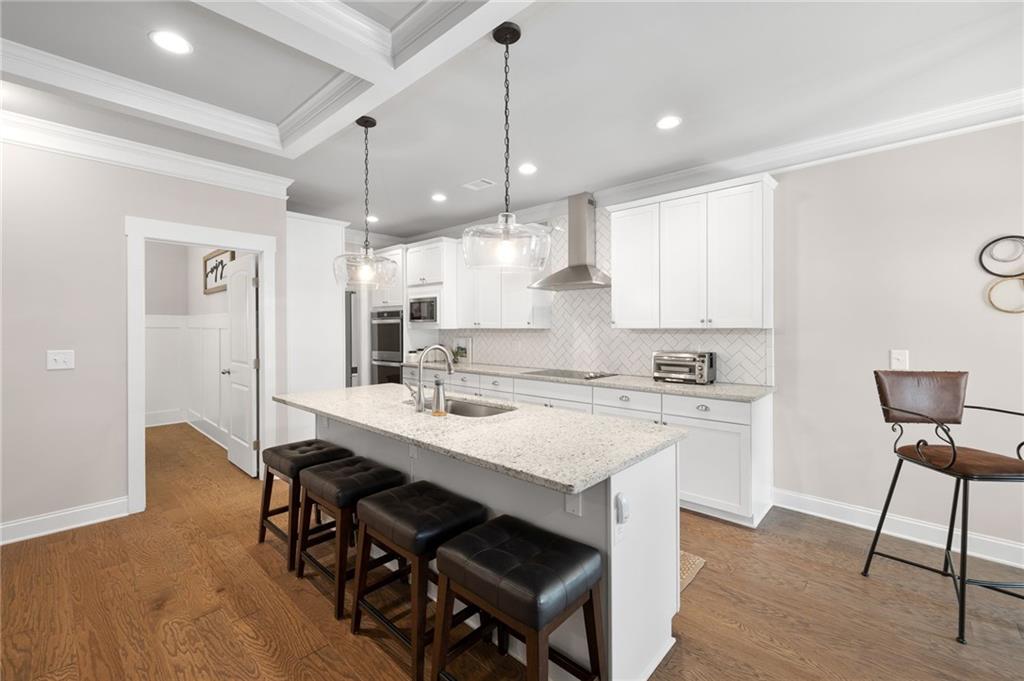 2440 Traditions Way Jefferson, GA 30549 - Photo 5 of 32 a kitchen with stainless steel appliances granite countertop a sink a stove a refrigerator and island with wooden floor