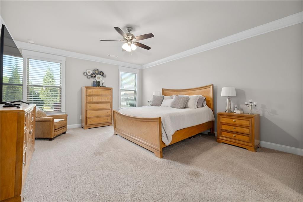 2440 Traditions Way Jefferson, GA 30549 - Photo 10 of 32 a bedroom with a bed and a chandelier