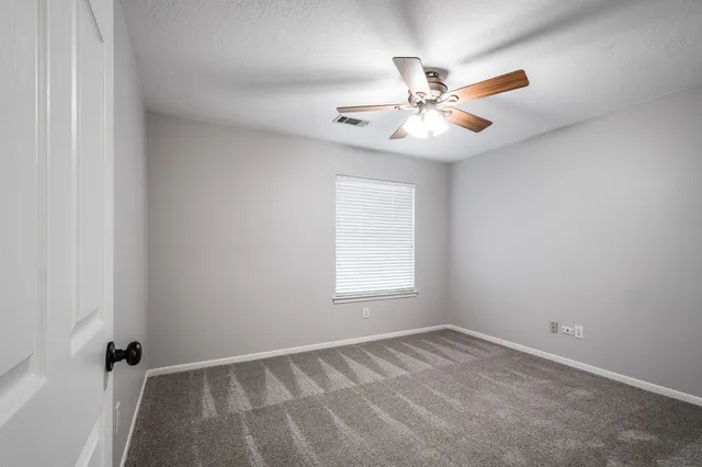 a view of a livingroom with a ceiling fan and window