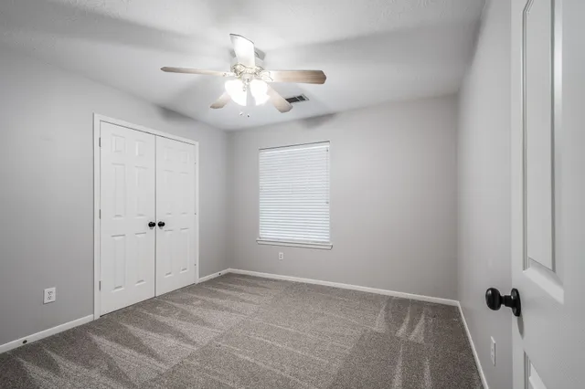 a view of empty room with a ceiling fan and window