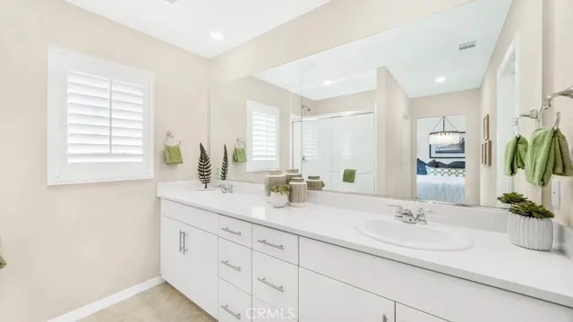 a bathroom with double vanity sinks a mirror and a shower