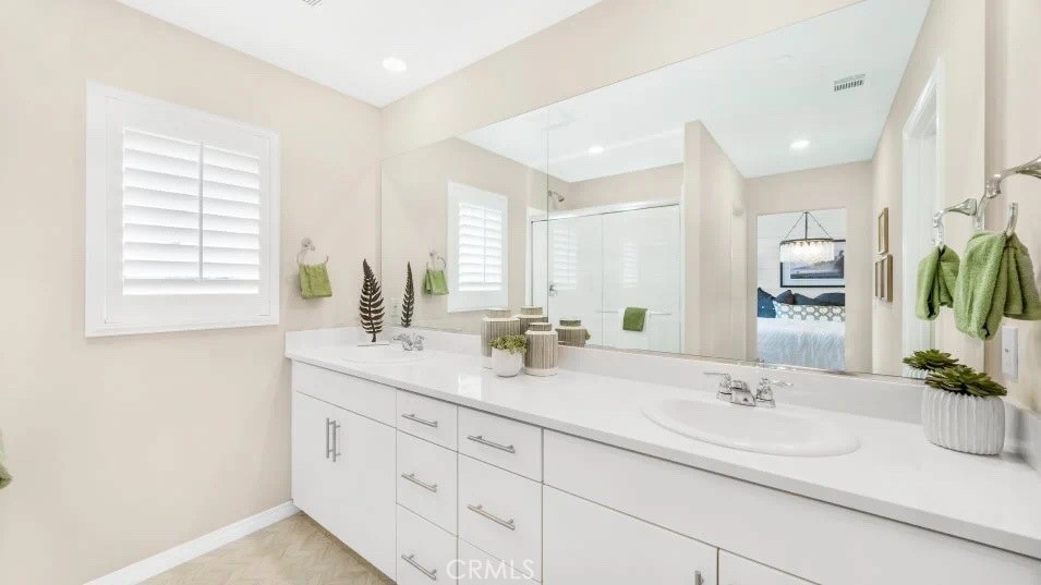7464 Fig Grv Lane Riverside, CA 92507 - Photo 11 of 17 a bathroom with double vanity sinks a mirror and a shower