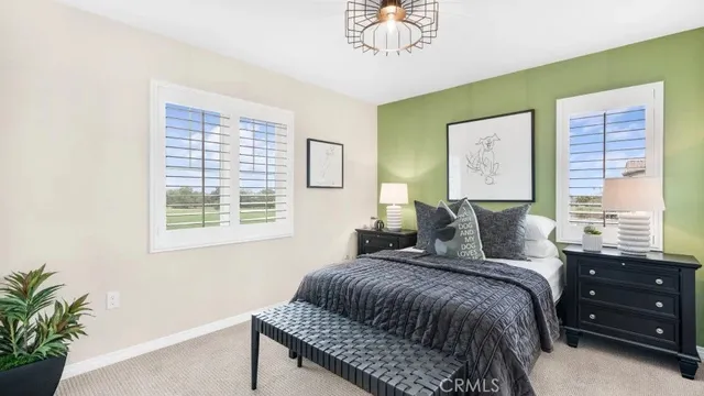 a bedroom with a bed chandelier and a window
