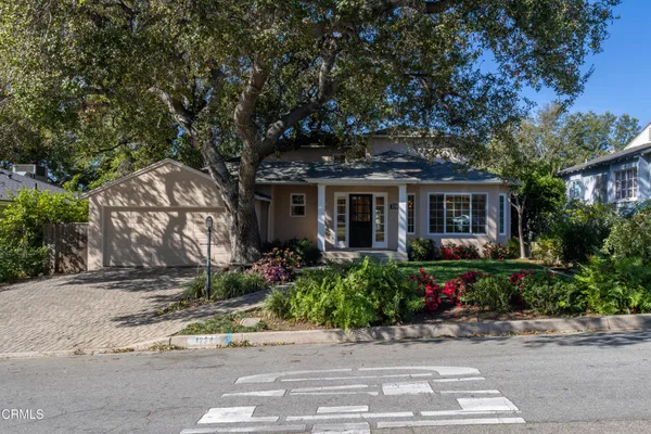 a front view of a house with a yard and potted plants