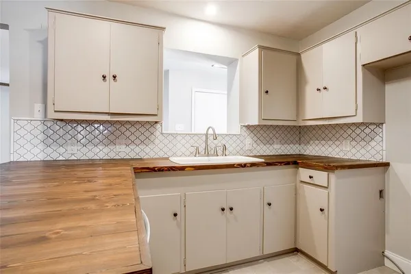 a kitchen with granite countertop white cabinets and a sink