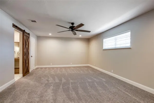 an empty room with windows and ceiling fan