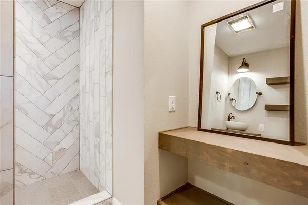 a bathroom with a mirror and a shower