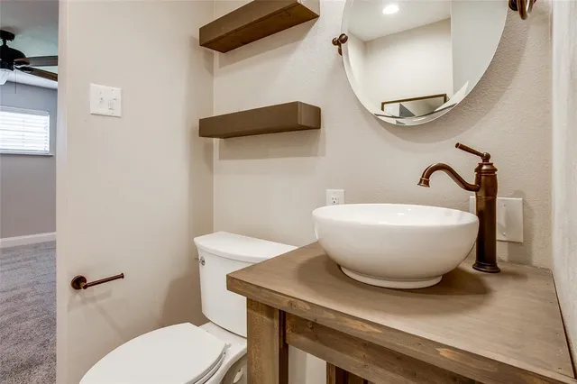 a bathroom with a toilet a sink and mirror