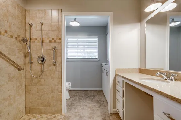 a bathroom with a sink shower and a mirror