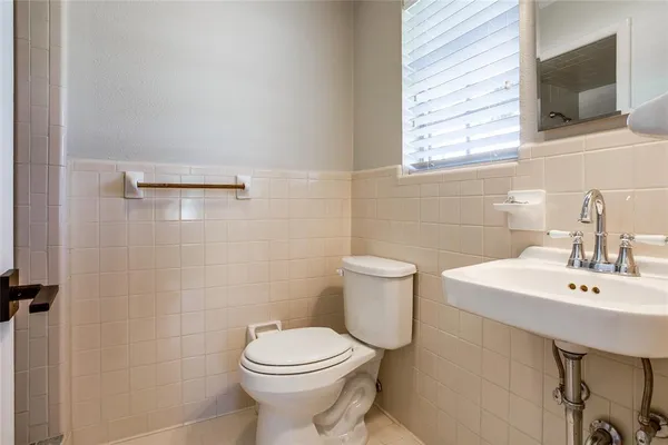 a bathroom with a sink a toilet and mirror