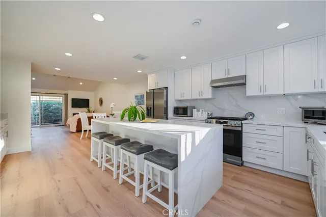 a kitchen with refrigerator and chairs