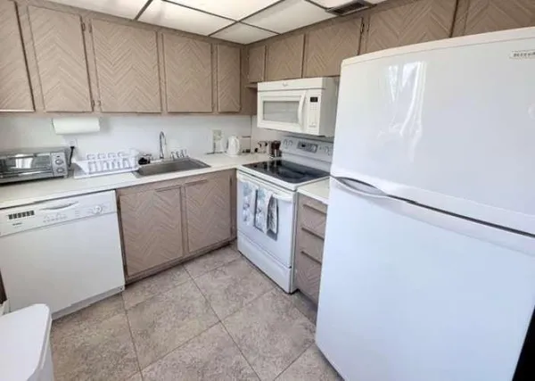 a kitchen with stainless steel appliances a refrigerator sink and white cabinets